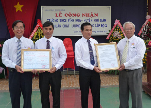 Giám đốc Sở Giáo dục - Đào tạo Dương Thế Phương (bìa phải) trao bằng công nhận trường đạt chuẩn chất lư