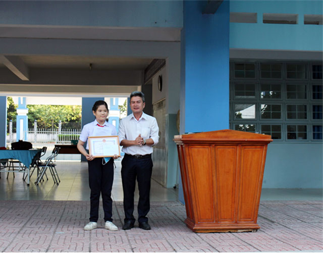 Ông Hồ Quốc Cảnh – Chủ tịch UBND phường Tân An, trao quyết định giấy khen và tiền thưởng cho em Nguyễn Ngọc Thảo